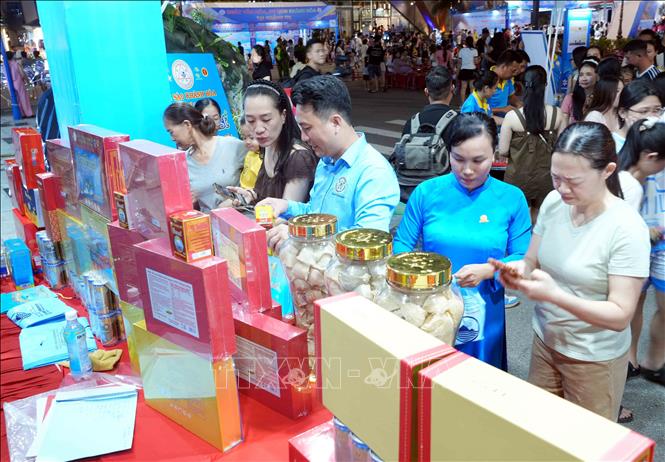 Du khách tìm hiểu, mua sản phẩm Yến sào Khánh Hòa bên lề chương trình Khai mạc. Ảnh: Tá Chuyên - TTXVN