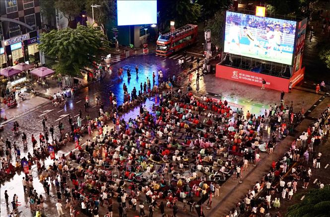 Người hâm mộ TP. Hồ Chí Minh phải đội mưa cổ vũ cho đội tuyển Việt Nam trong những phút đầu của trận đấu bán kết lượt đi. Ảnh: Trung Tuyến - TTXVN 