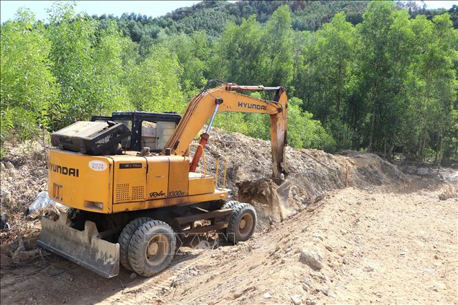 Máy móc làm việc tại công trình hố chôn lấp tạm thời. Ảnh: Đinh Hương - TTXVN