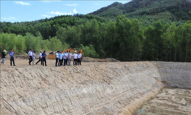 Đoàn công tác kiểm tra thực tế hố chôn lấp mới đang được xây dựng. Ảnh: Đinh Hương - TTXVN