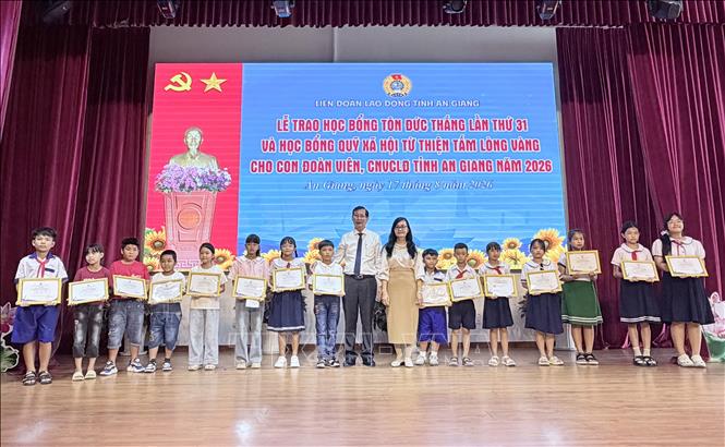 Lãnh đạo tỉnh An Giang trao học bổng tấm lòng vàng cho học sinh có hoàn cảnh khó khăn. Ảnh: Thanh Sang-TTXVN