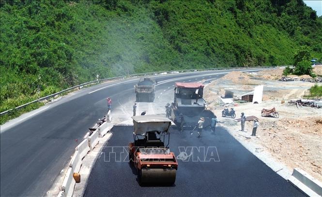 Nhà thầu gấp rút thi công thảm nhựa sẵn sàng thông tuyến chính vào 31/8 tới. Ảnh: Quốc Khánh - TTXVN