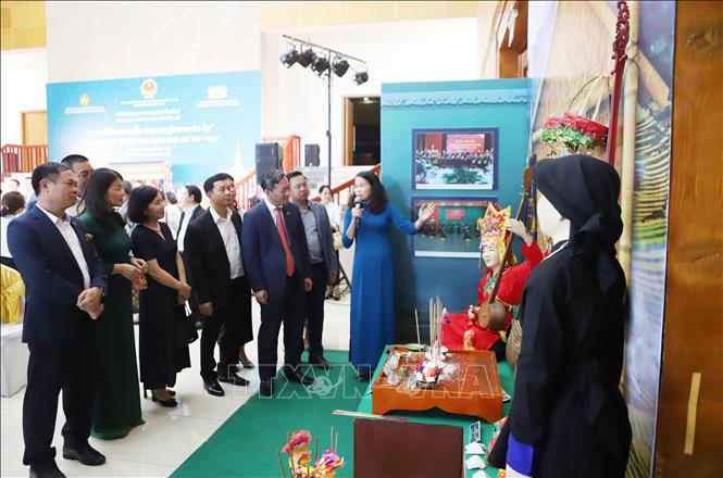 Các đại biểu hai nước tham quan không gian trưng bày văn hóa Then chuyên đề “Thực hành tín ngưỡng Then nhóm ngôn ngữ Tày - Thái” tại sự kiện. Ảnh: Xuân Tú - PV TTXVN tại Lào