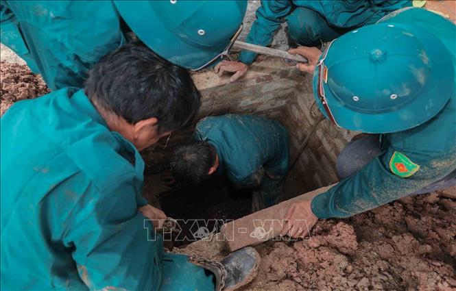 Khai quật hài cốt liệt sĩ chưa xác định danh tính tại Nghĩa trang trang liệt sĩ Liên Hiệp (xã Hát Môn). Ảnh: Phan Phương - TTXVN