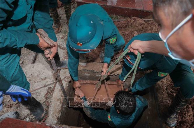 Khai quật hài cốt liệt sĩ chưa xác định danh tính tại Nghĩa trang trang liệt sĩ Liên Hiệp (xã Hát Môn). Ảnh: Phan Phương - TTXVN