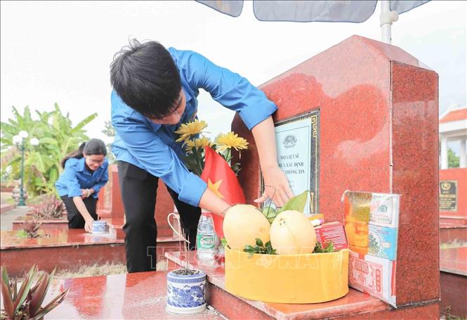 Thực hiện việc mã hóa các phần mộ được thực hiện cẩn thận trước khi tiến hành khai quật lấy mẫu sinh phẩm tại Nghĩa trang liệt sĩ Liên Hiệp (xã Hát Môn). Ảnh: Phan Phương - TTXVN