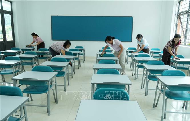 Các giáo viên lau dọn bàn ghế tại các lớp học ở Trường Phổ thông nội trú liên cấp Tiểu học và Trung học cơ sở Phong Thổ. Nguyễn Oanh-TTXVN