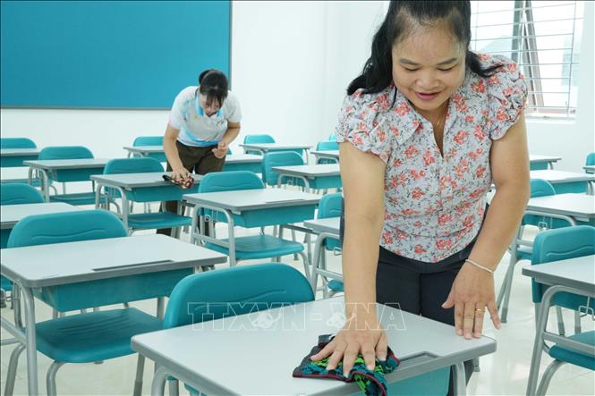 Các giáo viên lau dọn bàn ghế tại các lớp học ở Trường Phổ thông nội trú liên cấp Tiểu học và Trung học cơ sở Phong Thổ. Nguyễn Oanh-TTXVN