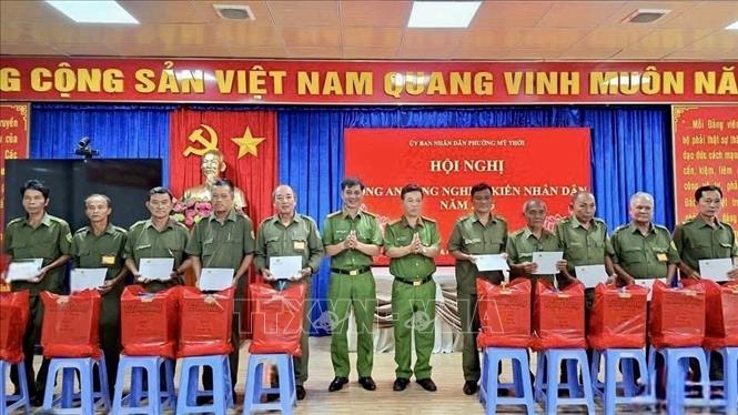 Đại diện Công an phường Mỹ Thới, tỉnh An Giang trao quà hỗ trợ người dân có hoàn cảnh khó khăn. Ảnh: Thanh Sang - TTXVN