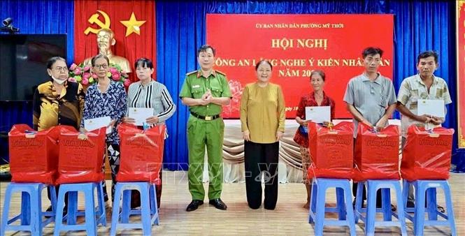 Công an phường Mỹ Thới, An Giang và Ủy ban MTTQ Việt Nam phường trao quà cho các hộ dân có hoàn cảnh khó khăn trên địa bàn. Ảnh: Thanh Sang - TTXVN
