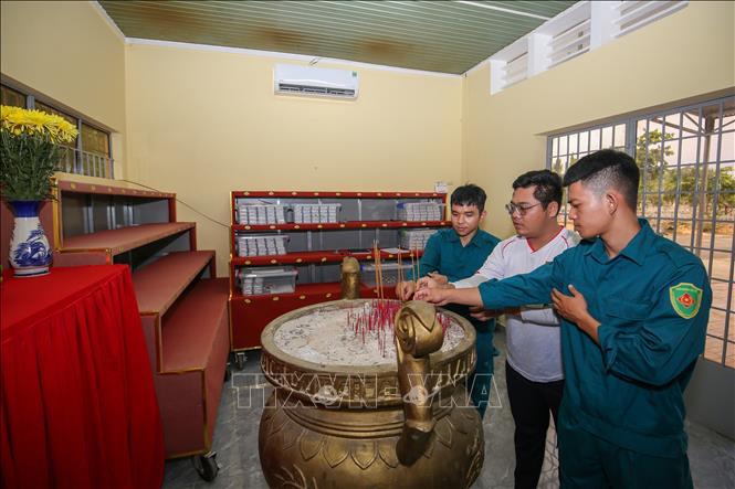 Cán bộ, chiến sĩ thắp nén nhang tưởng nhớ, tri ân các Anh hùng liệt sĩ sau khi hoàn thành việc bàn giao mẫu tại nhà lưu mẫu. Ảnh: Giang Phương - TTXVN