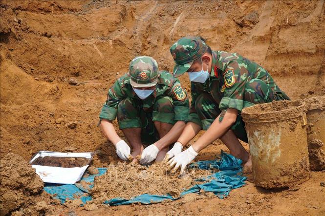 Công tác tìm kiếm, quy tập hài cốt liệt sĩ tại khu mộ tập thể ở ấp Lạc An 3, xã Thường Tân. Ảnh: TTXVN phát