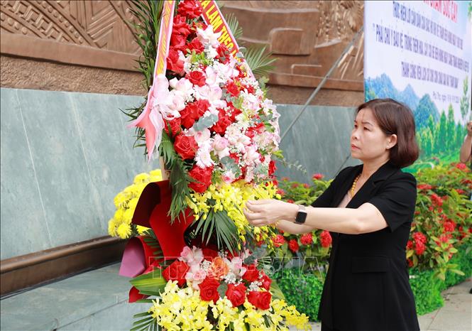 Bà Phùng Thị Kim Nga, Phó Chủ tịch UBND tỉnh Phú Thọ dâng hoa tại Bức phù điêu có hình tượng Bác Hồ nói chuyện với cán bộ, chiến sĩ Đại đoàn 308 Quân Tiên Phong. Ảnh: Thu Hương - TTXVN