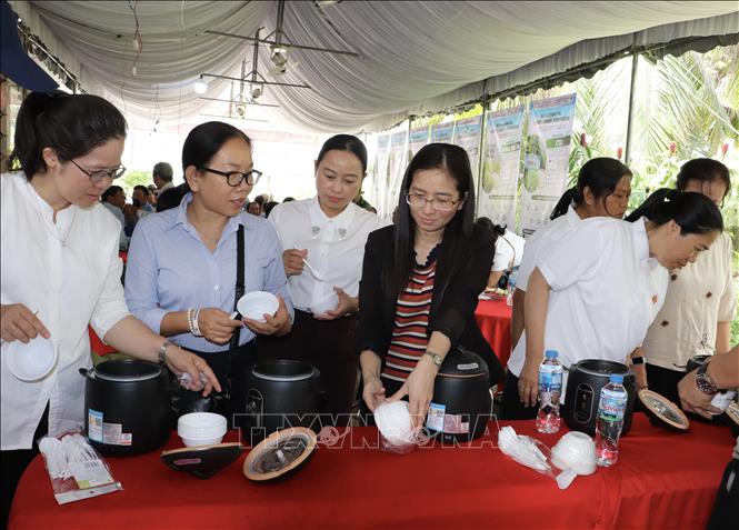 Các đại biểu thưởng thức cơm nấu từ gạo Nông Dân 1 và Nông Dân 2. Ảnh: Hồng Nhung - TTXVN