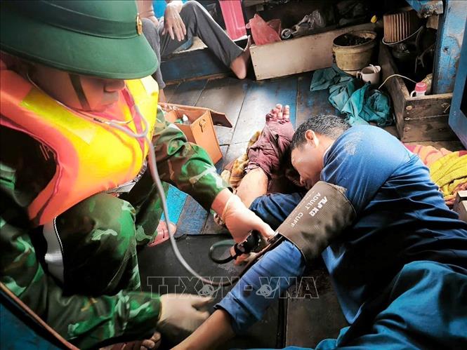 Thuyền viên Nguyễn Văn Hải được cán bộ quân y sơ cứu, cầm máu. Ảnh: TTXVN phát