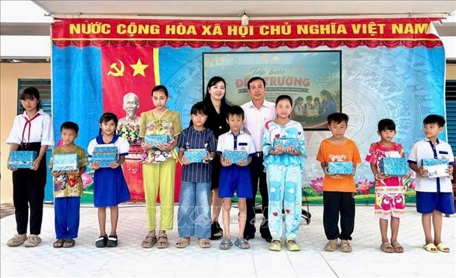 Lãnh đạo xã An Châu, An Giang và các đơn vị tài trợ trao học bổng, quà tiếp sức đến trường cho học sinh có hoàn cảnh khó khăn. Ảnh: Thanh Sang - TTXVN
