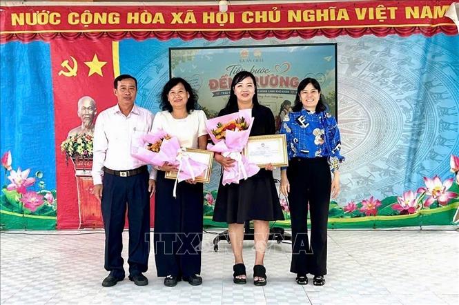 Lãnh đạo UBND xã An Châu, An Giang, tặng giấy khen tri ân các đơn vị tài trợ học bổng cho các học sinh có hoàn cảnh khó khăn. Ảnh: Thanh Sang - TTXVN
