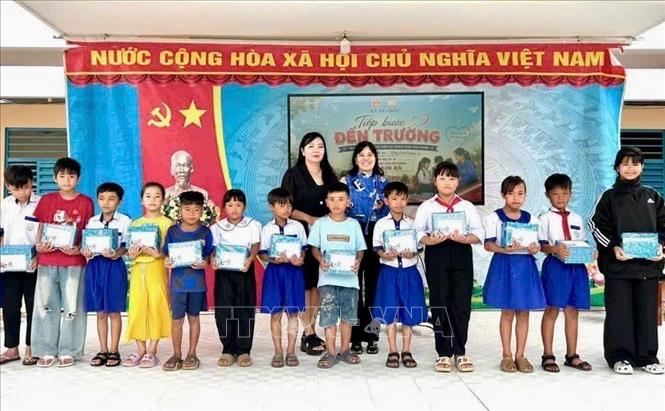 Lãnh đạo xã An Châu, An Giang, và các đơn vị tài trợ trao học bổng, quà tiếp sức đến trường cho học sinh có hoàn cảnh khó khăn. Ảnh: Thanh Sang - TTXVN
