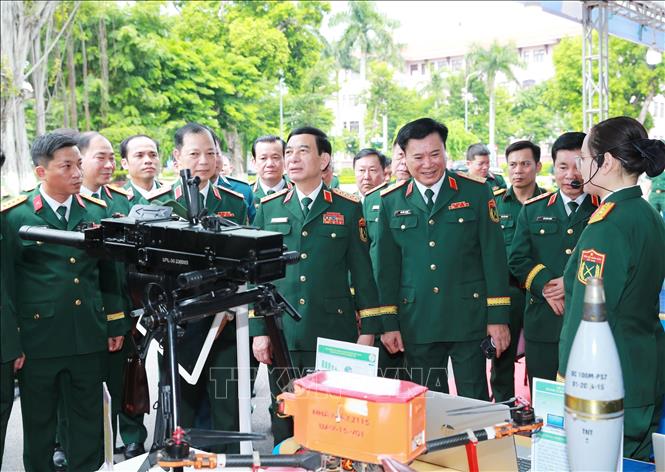 Phó Thủ tướng, Bộ trưởng Quốc phòng Phan Văn Giang và các đại biểu tham quan khu trưng bày sản phẩm công nghệ quốc phòng của các đơn vị. Ảnh: Trọng Đức - TTXVN