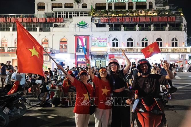 Du khách nước ngoài hòa cùng niềm vui chiến thắng của đội tuyển Việt Nam. Ảnh: Phạm Tuấn Anh - TTXVN