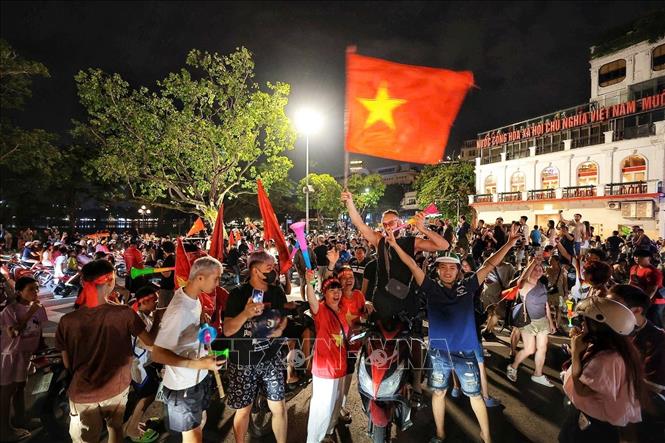 Du khách nước ngoài hòa cùng niềm vui chiến thắng của đội tuyển Việt Nam. Ảnh: Phạm Tuấn Anh - TTXVN