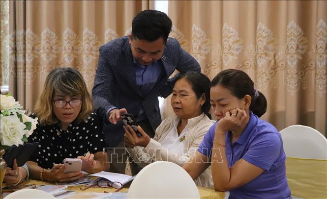 Hướng dẫn học viên thực hành trên điện thoại. Ảnh: Nguyễn Hằng - TTXVN