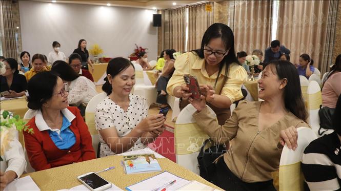 Đại diện Hội Liên hiệp phụ nữ thành phố hỗ trợ học viên thực hành ứng dụng AI trên điện thoại. Ảnh: Nguyễn Hằng - TTXVN