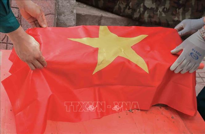 Thực hiện nghi thức phủ Quốc kỳ trang trọng, tri ân Anh hùng liệt sĩ đã hy sinh vì độc lập, tự do của Tổ quốc tại Nghĩa trang liệt sĩ Minh Phú, xã Kim Anh, Hà Nội. Ảnh: Phan Phương - TTXVN