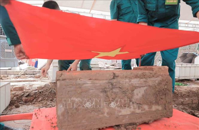 Thực hiện nghi thức phủ Quốc kỳ trang trọng, tri ân Anh hùng liệt sĩ đã hy sinh vì độc lập, tự do của Tổ quốc tại Nghĩa trang liệt sĩ Minh Phú xã Kim Anh, Hà Nội. Ảnh: Phan Phương - TTXVN