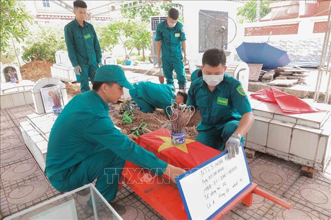 Thực hiện nghi thức phủ Quốc kỳ trang trọng, tri ân Anh hùng liệt sĩ đã hy sinh vì độc lập, tự do của Tổ quốc tại Nghĩa trang liệt sĩ Minh Phú, xã Kim Anh, Hà Nội. Ảnh: Phan Phương - TTXVN