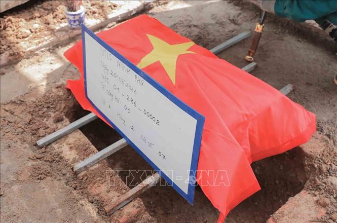 Hài cốt liệt sĩ sau khi lấy mẫu giám định ADN được an táng trang nghiêm, trọng thể tại Nghĩa trang liệt sĩ Minh Phú, xã Kim Anh, Hà Nội. Ảnh: Phan Phương – TTXVN