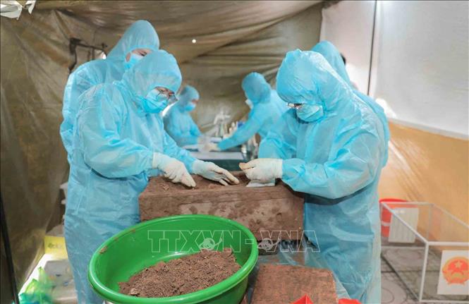 Công tác lấy mẫu sinh phẩm (ADN) tại Nghĩa trang  liệt sĩ Minh Phú, xã Kim Anh, Hà Nội được thực hiện hết sức cẩn thận, đúng quy trình kỹ thuật, đảm bảo độ chính xác tuyệt đối. Ảnh: Phan Phương - TTXVN