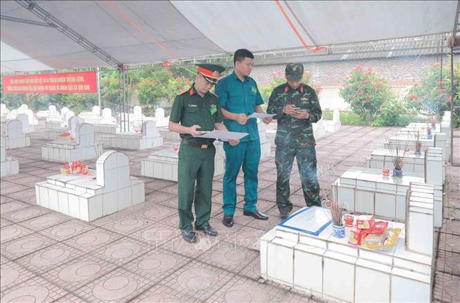 Việc mã hóa các phần mộ được thực hiện cẩn thận trước khi tiến hành lấy mẫu sinh phẩm. Ảnh: Phan Phương - TTXVN