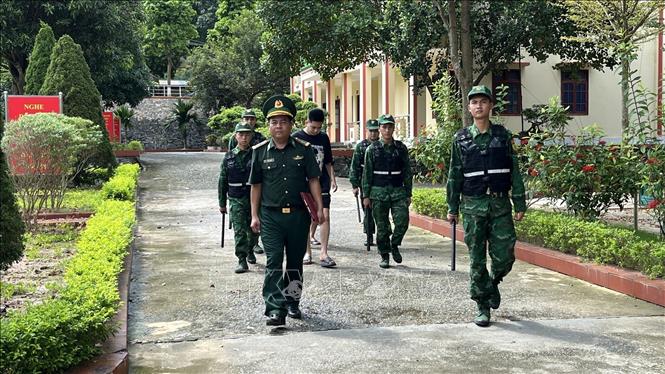Dẫn giải các đối tượng về Đồn Biên phòng để điều tra làm rõ. Ảnh: TTXVN phát