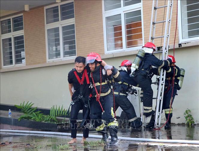 Lực lượng Cảnh sát PCCC và Cứu nạn cứu hộ đưa bệnh nhân ra khỏi khu vực cháy. Ảnh: Văn Sĩ - TTXVN