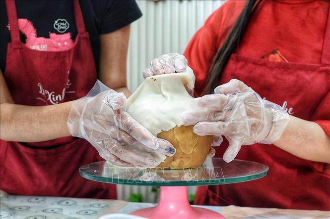 Gradually shaping a vase designed to hold flower stems crafted using mooncake-making techniques. VNA Photo: Phạm Tuấn Anh