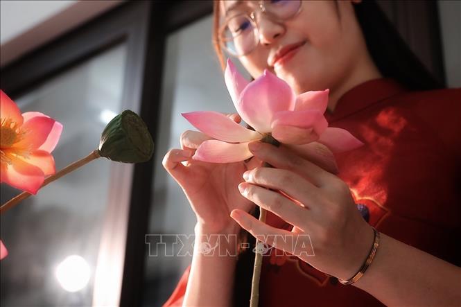 After completing the layers of petals, the artisan continues to adjust the lotus flower's shape before attaching it to the stem and receptacle. VNA Photo: Phạm Tuấn Anh