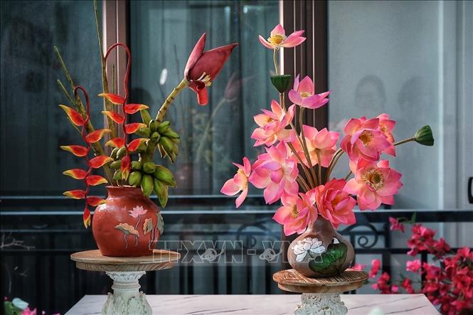 Vases of lotus and banana blossoms—crafted from mooncake and *tò he* (traditional dough figurine) materials—are finished in a variety of shades and styles, making it difficult for viewers to realize they are edible creations. VNA Photo: Phạm Tuấn Anh