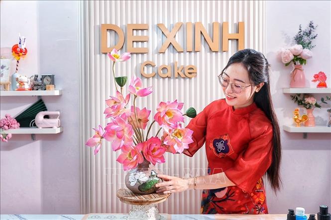 The finished product combines two shaping techniques: the vase itself is made from mooncake dough, while the lotus stems above are hand-sculpted from *tò he* (traditional dough figurine) paste. This combination gives the mooncake the appearance of an artistic flower vase. VNA Photo: Phạm Tuấn Anh