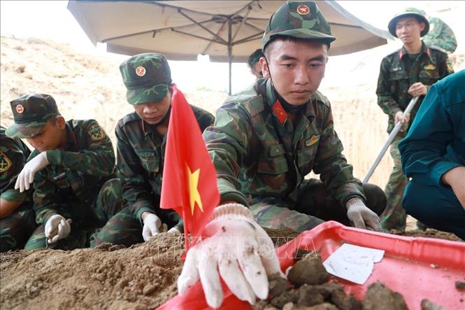 Cán bộ chiến sĩ Đội Quy tập hài cốt liệt sĩ cẩn trọng, nâng niu từng di vật và mẫu hài cốt. Ảnh: Xuân Triệu - TTXVN