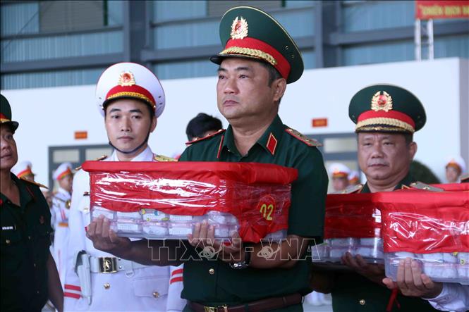 Trung tướng Lê Xuân Thế, Tư lệnh Quân khu 7 kính cẩn chuyển mẫu mẫu sinh phẩm hài cốt liệt sĩ lên máy bay vận chuyển ra Hà Nội để phục vụ công tác xét nghiệm ADN xác định danh tính liệt sĩ. Ảnh: Xuân Khu - TTXVN