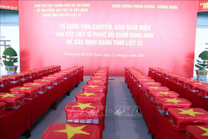Các mẫu sinh phẩm hài cốt liệt sĩ được niêm phong, đóng gói nghiêm ngặt vào thùng chuyên dụng, phủ Quốc kỳ trước khi được đưa lên máy bay. Ảnh: Xuân Khu - TTXVN