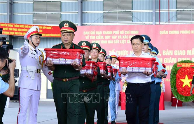 Trung tướng Lê Xuân Thế, Tư lệnh Quân khu 7; ông Nguyễn Mạnh Cường, Phó Chủ tịch UBND Thành phố, Trưởng ban Ban Chỉ đạo Thành phố kính cẩn chuyển mẫu sinh phẩm hài cốt liệt sĩ lên máy bay vận chuyển ra Hà Nội để phục vụ công tác giám định ADN, xác định danh tính liệt sĩ. Ảnh: Xuân Khu - TTXVN