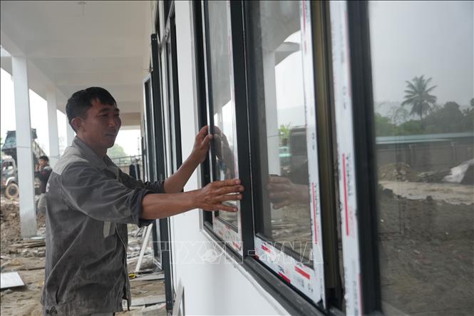 Huy động lực lượng hoàn thành các hạng mục còn lại để đón học sinh vào năm học mới tại Trường Phổ thông nội trú liên cấp Tiểu học và Trung học cơ sở Anh Sơn, xã Anh Sơn. Ảnh: Bích Huệ - TTXVN