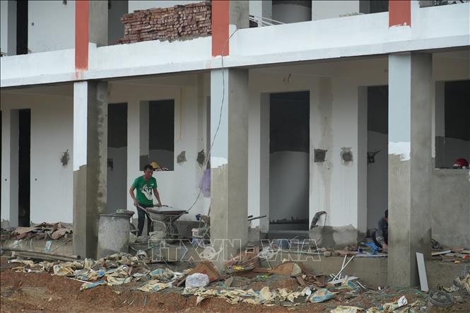 Tại Trường Phổ thông nội trú liên cấp Tiểu học và Trung học cơ sở Anh Sơn, xã Anh Sơn, nhiều nhóm công nhân làm việc đồng thời. Ảnh: Bích Huệ - TTXVN