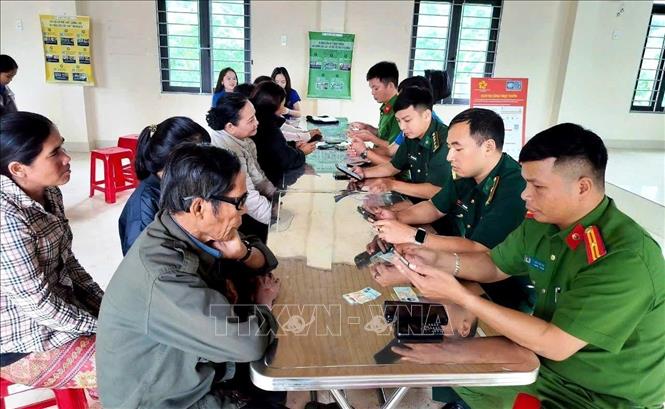 Cán bộ, lực lượng Công an, Quân đội và đoàn viên thanh niên nhiệt tình hướng dẫn người dân cài đặt các ứng dụng, thao tác kỹ năng số. Ảnh: Võ Dung - TTXVN