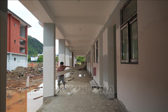 Tại công trường Trường Phổ thông nội trú liên cấp Tiểu học và Trung học cơ sở Anh Sơn, xã Anh Sơn, công nhân tận dụng từng khoảng thời gian, tập trung hoàn thành các phần việc theo kế hoạch. Ảnh: Bích Huệ - TTXVN