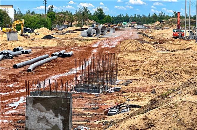 Các nhà thầu tập trung đẩy nhanh tiến độ thi công hoàn thiện đoạn 1,5km đường đầu cầu phía Đông đưa công trình vào sử dụng. Ảnh: Nguyên Linh-TTXVN