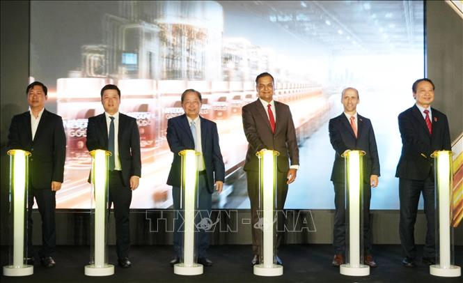 Các đại biểu thực hiện nghi thức vận hành dây chuyền đóng gói cà phê hòa tan trong hũ thủy tinh (Jar Line) tại Nhà máy Nestlé Trị An, thành phố Đồng Nai. Ảnh: Công Phong - TTXVN