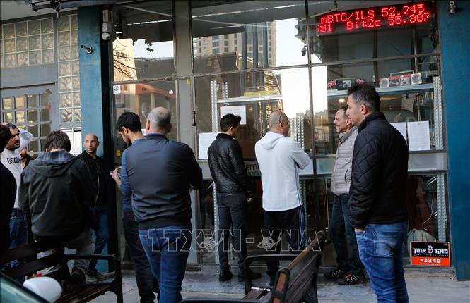 Người dân mua bitcoin tại phòng giao dịch ở Tel Aviv, Israel. Ảnh: THX/TTXVN phát